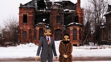 Performance artists is gas masks use decaying Detroit as a backdrop in a scene f